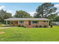 Charming brick home with green shutters and a spacious front yard under a blue sky at 10900 Poole Rd, Wendell, NC 27591