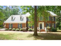 Charming two-story brick home with blue shutters and a well-manicured lawn and mature landscaping at 12037 Deer Run, Raleigh, NC 27614