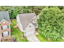 A beautifully landscaped traditional-style home features a two-car garage and mature trees on a generous lot at 1304 Trailing Rose Ct, Wake Forest, NC 27587