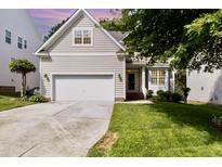 Charming beige two-story home featuring an attached garage and well-manicured lawn at 1304 Trailing Rose Ct, Wake Forest, NC 27587
