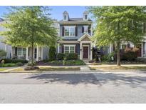 Charming two-story home with blue siding, brown shutters and a nicely landscaped front yard and trees at 1625 Main Divide Dr, Wake Forest, NC 27587
