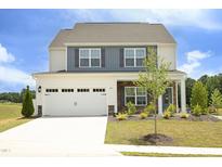 Charming two-story home with a two-car garage, gray shutters, and meticulously manicured landscaping at 200 Sweet Violet Dr, Youngsville, NC 27596