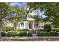 Charming two-story home with a well-manicured lawn, white picket fence, and inviting front porch with an American flag at 2027 Hopeton Ave, Raleigh, NC 27614