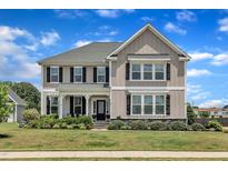 Charming two-story home featuring a well-manicured lawn and beautiful landscaping at 243 E Wellesley Dr, Clayton, NC 27520