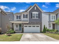 Charming two-story home featuring gray siding, stone accents, a two-car garage, and a well-manicured lawn at 2969 Thirlestane Dr, Apex, NC 27502