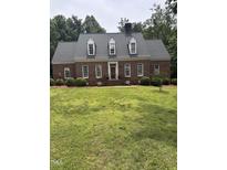 Charming brick home with dormer windows and a well-manicured lawn at 305 Lochridge Dr, Roxboro, NC 27573
