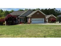 Charming single-story brick home with well-manicured lawn and landscaping at 3409 Bennyfield Ct, Fuquay Varina, NC 27526