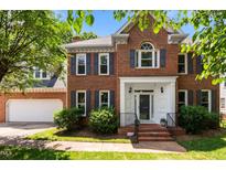 Charming brick home with a well-manicured lawn, gray shutters and a welcoming front entrance at 3720 Bridgeton Park Dr, Raleigh, NC 27612