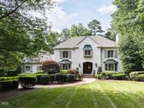 Elegant white brick home showcasing manicured landscaping and inviting curb appeal at 5005 Lenoraway Dr, Raleigh, NC 27613