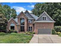 Stunning two-story brick home featuring a manicured lawn and a two-car garage at 5309 Overtop Ln, Raleigh, NC 27613