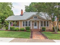 Charming home featuring a brick walkway, manicured landscaping, and inviting front porch at 601 E Franklin St, Raleigh, NC 27604