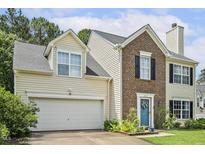 Two-story home featuring a combination of brick and siding, with an attached garage and well-maintained front yard at 601 Texanna Way, Holly Springs, NC 27540