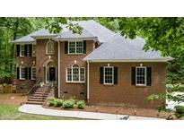 Two-story brick home with black shutters, a gray roof, and manicured landscaping at 603 Edburton Ct, Hillsborough, NC 27278