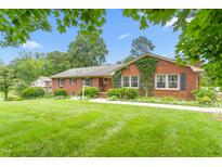 Charming brick home featuring a lush green lawn and mature landscaping at 619 S Fifth St, Mebane, NC 27302
