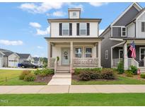 Charming two-story home with a welcoming front porch and a well-maintained lawn at 710 Vine Pkwy, Pittsboro, NC 27312