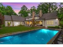 Stunning backyard featuring a sparkling pool, stone patio, and lush landscaping perfect for outdoor entertaining at 800 Lakestone Dr, Raleigh, NC 27609