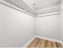 A bright walk-in closet featuring hardwood floors and white shelving at 1006 S Second Ave Ave, Siler City, NC 27344