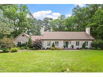 Charming brick home with mature landscaping, lush green lawn and inviting curb appeal at 1023 Cleland Dr, Chapel Hill, NC 27517