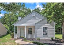 Charming home featuring a covered entryway, light siding, and manicured landscaping at 1202 Kendall Dr, Durham, NC 27703