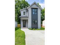 Charming two-story home featuring modern architectural design with a concrete driveway and well-maintained lawn at 1410 Joe Louis Ave, Raleigh, NC 27610