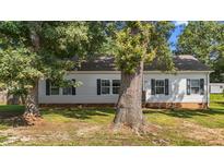 Charming single-story home featuring vinyl siding and complemented by mature trees in a serene, landscaped setting at 1442 Morningside Dr, Burlington, NC 27217