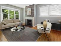 Inviting living room with fireplace, large window, neutral color palette and hardwood floors at 1521 N Duke St, Durham, NC 27701