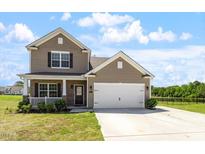 Inviting two-story home featuring a covered porch, attached garage, and well-maintained lawn in a desirable neighborhood at 167 Young Farm Dr, Lillington, NC 27546