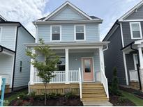 Charming two-story home with a welcoming porch and a pink front door at 1915 Plott Balsam Dr, Wendell, NC 27591