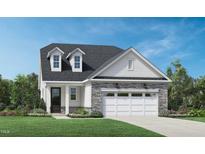 Charming home exterior with stone accents, dormer windows, attached garage, and a beautifully landscaped front yard at 2036 Abbeyhill Dr # 99, Raleigh, NC 27610