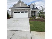 Charming single-Gathering home featuring stone accents, a two-car garage, and well-maintained landscaping at 2036 Abbeyhill Dr # 99, Raleigh, NC 27610