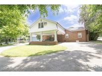Brick home featuring a covered carport, concrete driveway, and well-maintained lawn at 219 E Nash St, Spring Hope, NC 27882
