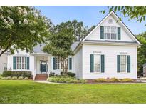 Charming white home with green shutters, a manicured lawn, and mature trees at 2311 Woodwyck Way, Raleigh, NC 27604