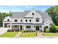 Beautiful white exterior with manicured lawn and covered porch seating area at 2508 Kearney Rd, Wake Forest, NC 27587