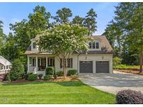 Charming home boasts a well-manicured lawn, flowering tree, and convenient two-car garage at 3034 Lewis Farm Rd, Raleigh, NC 27607