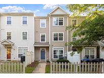 Three-story townhouse with neutral siding, white trim, and a small fenced front yard at 330 Gilman Ln # 109, Raleigh, NC 27610