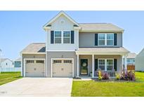 Charming two-story home featuring a two-car garage, manicured lawn, and welcoming front porch at 341 Henry Steel Dr, Gibsonville, NC 27249