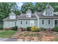 Inviting exterior of a townhouse with a manicured lawn and appealing architectural details and concrete steps and white rails at 410 Oak Run Dr, Raleigh, NC 27606