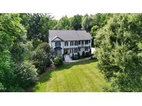 An aerial view of a beautifully landscaped home with a large lawn and surrounding trees at 4217 Grahamstone Rd, Raleigh, NC 27610