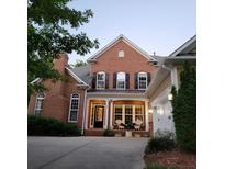 Charming brick home featuring a front porch with chairs and a well-maintained front yard at 502 Willowmere Ct, Cary, NC 27513