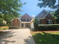 Charming brick home featuring a well-manicured lawn, symmetrical design, and inviting front porch at 502 Willowmere Ct, Cary, NC 27513