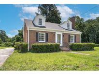 Charming brick home featuring black shutters, a manicured lawn, and a classic architectural style at 631 Park Ave, Rocky Mount, NC 27801
