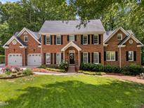 Traditional brick home with black shutters, well-maintained landscaping, and a two-car garage at 8004 Gabriels Bend Dr, Raleigh, NC 27612