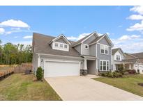 Charming two-story home with a two-car garage and well-manicured front lawn at 815 Harmony Ranch Ln, Franklinton, NC 27525