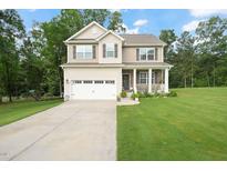 Charming two-story home with a well-maintained lawn, inviting front porch, and attached two-car garage at 947 Weatherby Ln, Creedmoor, NC 27522