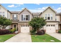 Charming townhome with attached garages, manicured lawn, and inviting curb appeal at 107 Tuftin Dr, Durham, NC 27703