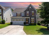 Charming two-story home featuring a stone facade, manicured lawn, and a two-car garage at 1127 Timbercut Dr, Durham, NC 27703