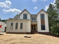 New construction two-story home with white siding, black trim, and an unfinished front yard at 155 Cherry Bark Dr, Youngsville, NC 27596