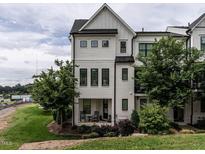 Charming three-story townhouse boasts white brick, black trim and inviting front porch with lush landscaping at 1610 Draper View Loop # 101, Raleigh, NC 27608