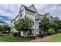 Beautiful white townhome featuring black trim, multiple windows and professionally landscaped yard at 1610 Draper View Loop # 101, Raleigh, NC 27608