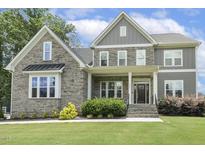 Charming two-story home with stone and gray siding, manicured lawn, and inviting front porch at 1625 Banks View Dr, Raleigh, NC 27603